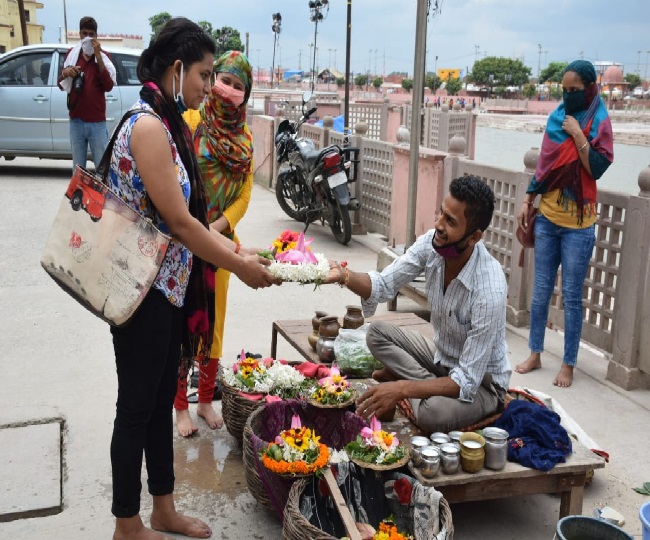 अयोध्या के क्षीरेश्वर नाथ मंदिर पर दर्शन-पूजन के लिए फूल माला खरीदती श्रद्धालू
