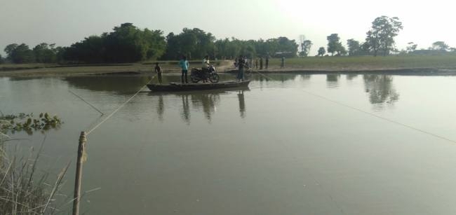 रहुआ धार में पुल नहीं रहने से नाव से पार होते हैं लोग