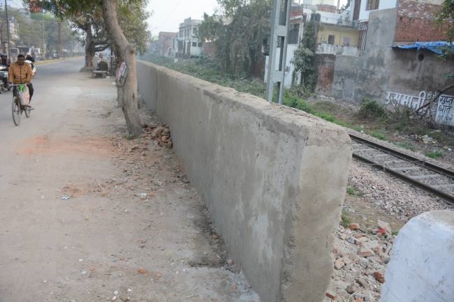 पीली ईंट पर बालू लगाकर रेलवे ने बना दी बाउंड्रीवाल