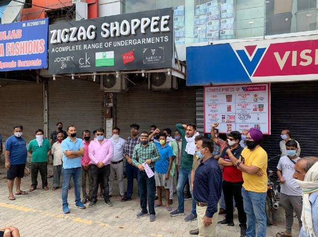 दुकानें बंद करने के फरमान का दुकानदारों ने किया विरोध, काली पट्टी लगाई