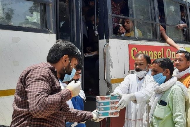प्रवासियों को वितरित किए लंच पैकेट