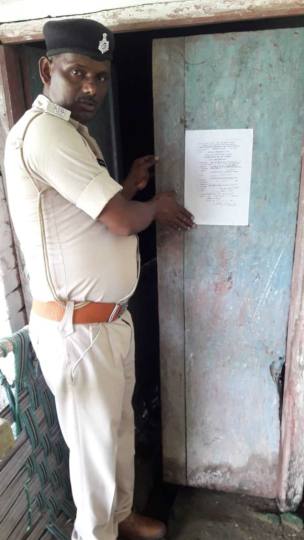फरार अभियुक्तों के घर पर पुलिस ने चस्पाया इश्तेहार