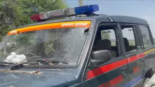 पुलिस की गाड़ी का शीशा टूट गया