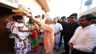 मिष्ठान वितरण के दौरान एक बच्ची को दुलारते हुए मुख्यमंत्री योगी आदित्यनाथ। सूचना विभाग