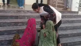 तहसीलदार के पैर पकड़कर न्याय की गुहार लगाती महिला।