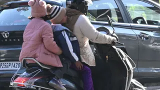 ठंड से बचने के लिए गर्म कपड़ों में कैद लोग।