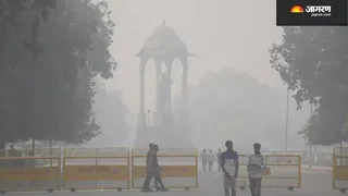 दिल्ली में धुंध के बीच गुजरते लोग।