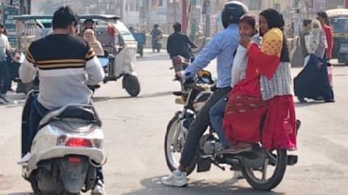 to avoid challan bikers used the pallu of the saree and someone folded the number plate
