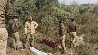 बक्से की जांच करते पुलिसकर्मी।