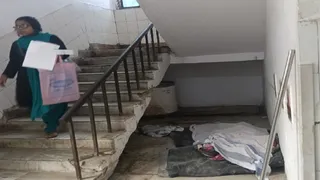 एसकेएमसीएच के इमरजेंसी वार्ड में सीढ़ी के नीचे पड़ा लावारिस शव। जागरण