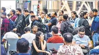 फ्लाइट कैंसिल होने पर एयरपोर्ट पर इंतजार करते यात्री। (पीटीआई)