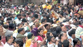 Banke Bihari Mandir में श्रद्धालुओं से प्रसाद लेकर अर्पित करने के लिए देते भोग भंडारी।