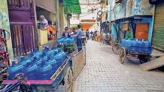 खोड़ा कॉलोनी में बोतलबंद पानी खरीदते लोग। जागरण