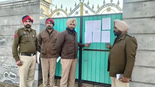 श्री मुक्तसर साहिब में नशा तस्कर के घर के बाहर नोटिस चिपकाते हुए पुलिस टीम।