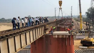 अंग्रेज जमाने के गार्डर हटाते क्रेन से रेलकर्मी। (जागरण)