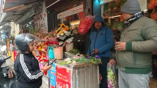 दुकान से फूल खरीदती युवती