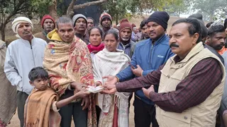 मृतक के परिजन को मुुआवजा राशि देते वन विभाग के अधिकारी।