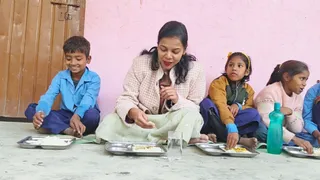 वैशाली जिले के भगवानपुर प्रखंड के सरकारी स्कूल में बच्चों के साथ मध्याह्न भोजन करतीं डीएम वर्षा सिंह। (जागरण)