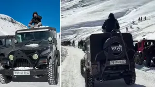 लाहुल में बफीर्ली सड़क पर पंजाब नंबर की गाड़ी में छत पर बैठकर सफर करता पर्यटक।