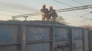 मालगाड़ी के वैगन में कोयले से उठी आग पर काबू पाते सीआइएसएफ के जवान।