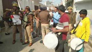 घर के बाहर ढोल बजवाती पुलिस