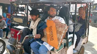 मथुराः वृंदावन में गौतम पाड़ा से सवारियां भरकर गुजरता ई-रिक्शा चालक। जागरण