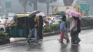 नई दिल्ली मंडी हाउस के पास हुई वर्षा से बचने के लिए कुछ इस तरह छतरी लेकर जाते लोग। ध्रुव कुमार