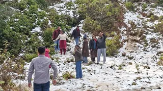 बर्फबारी के बीच फोटो खींचते पर्यटक। फाइल फोटो