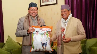 मुख्यमंत्री धामी अपने खेत में उत्पादित चावल पूर्व सीएम हरीश रावत को भेंट करते हुए।