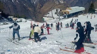 औली के स्लोप में स्की करते स्की प्रशिक्षण लेते स्कीइंग खिलाड़ी। जागरण