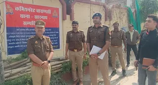 घर पर नोटिस चस्पा करते पुलिस अधिकारी। जागरण