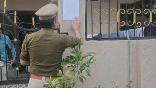 नोटिस चस्पा करती पुलिस।