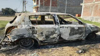 प्रयागराज के थरवई में कृष्णापुरी कॉलोनी में CRPF दारोगा की जली कार। जागरण