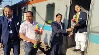 बुंदेलखंड एक्सप्रेस की महिला स्टाफ को पुष्प भेंट करते स्टेशन मैनेजर गजेंद्र राठौर। (सौजन्य: रेलवे)