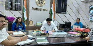 हाथरस में जिलाधिकारी अतुल वत्स के साथ बैठीं कनिका।