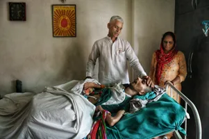 बेड पर हरीश राणा और उनके माता-पिता। फोटो: आर्काइव