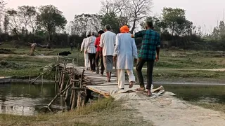मीरगंज क्षेत्र में भाखड़ा नदी पर बने लकड़ी के पुल से गुजरते ग्रामीण। जागरण