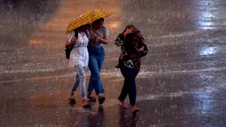 जोरदार बारिश के दौरान लखनऊ के हजरतगंज में जातीं युवतियां। - रंगनाथ तिवारी