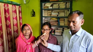 पुष्पांजलि को मिठाई खिलाते माता-पिता। (जागरण)