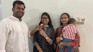 अंशिका को मिठाई खिलाते उनके भाई अनुभव वशिष्ठ भाभी शिल्पा। जागरण