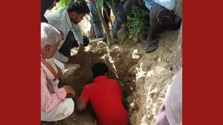 कब्र की खाेदाई के दौरान लोग।