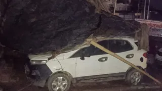 आगरा में आंधी के कारण कार की छत पर गिरा छप्पर।