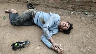 मारपीट की घटना के बाद सड़क पर बेसुध पड़ा घायल युवक।
