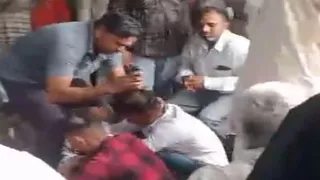 पंचायत में युवक का सिर मुंडवाते ग्रामीण।