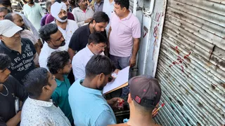 कोहाड़ापीर नैनीताल रोड की दुकानों पर निशान लगातीं नगर निगम की टीम। जागरण