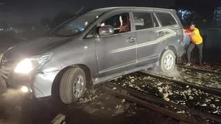 रेलवे ट्रैक पर फंसी कार। जागरण