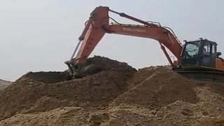 कौशांबी जिले के मल्हीपुर, नंदा का पूरा में डंप बालू को हटाता पोकलैंड। जागरण