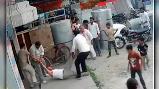 पूरनपुर में पूर्व सभासद को हाथ पैर पकड़कर घसीटते हुए बाहर लाते आरोपित। वीडियो ग्रैब