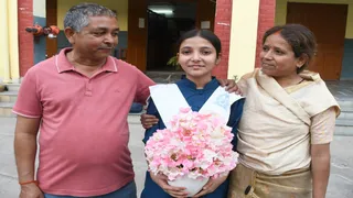 यूपी बोर्ड की हाईस्कूल परीक्षा 2026 में प्रयागराज जिले की टॉपर अविका शर्मा अपने माता-पिता संग। जागरण
