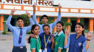 मवाना : एएस इंटर कालेज में जनपद में प्रथम स्थान प्राप्त करने वाली छात्रा वंशिका उपाध्याय को गोदी में उठाए खुशी सांझा करते बच्चे। जागरण